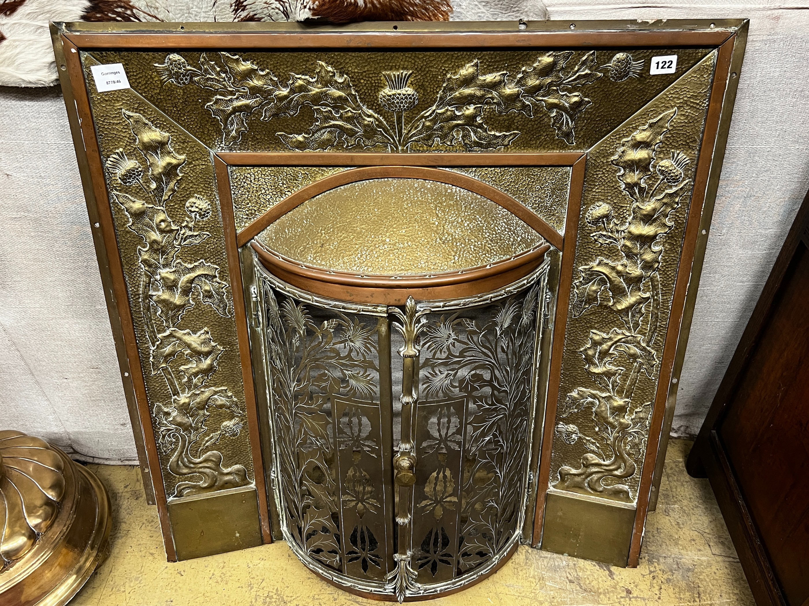 An Edwardian embossed brass and copper bowfront fire surround, width 86cm, height 89cm